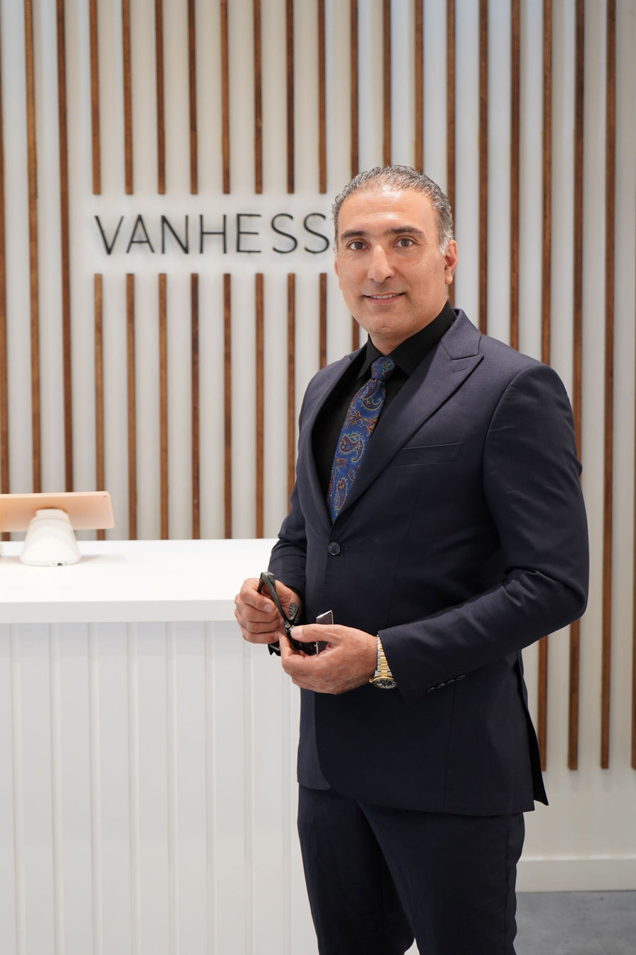 Mehran, owner and jeweller, in front of the Vanhess wall at the Coquitlam Centre studio