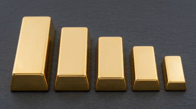 Five plain gold bullion bars of descending sizes arranged in a row on a dark charcoal surface